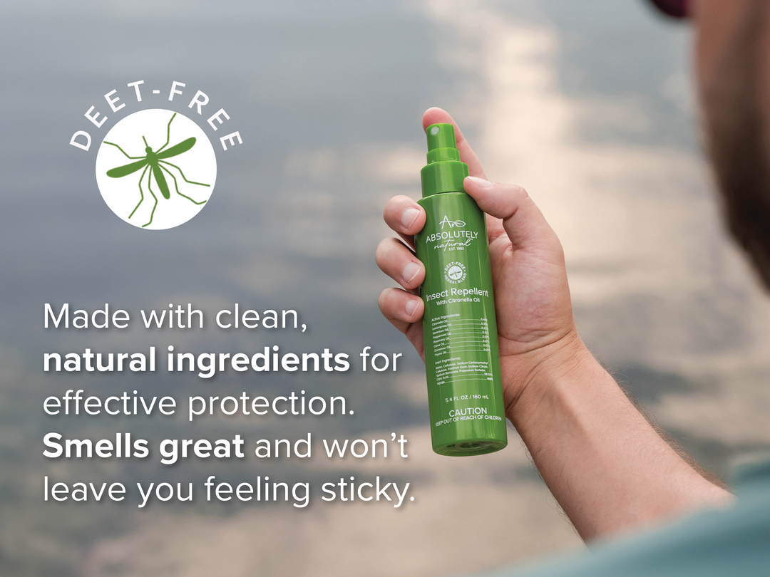 Hand holding Absolutely Natural DEET-Free Insect Repellent with Citronella Oil spray bottle outdoors, featuring natural ingredient benefits and non-sticky protection.