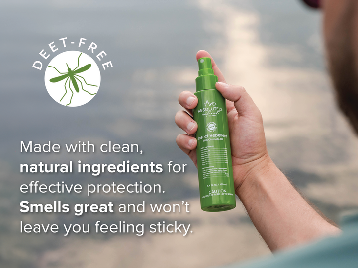 Hand holding Absolutely Natural DEET-Free Insect Repellent with Citronella Oil spray bottle outdoors, featuring natural ingredient benefits and non-sticky protection.