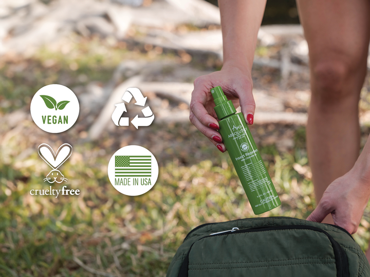 Hand holding Absolutely Natural DEET-Free Insect Repellent with Citronella Oil above a backpack outdoors, featuring vegan, cruelty-free, recyclable, and Made in USA icons.