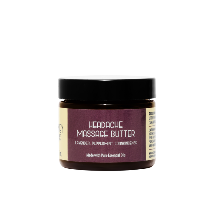 Front view of Kinsley Oils Headache Massage Butter with lavender, peppermint, and frankincense essential oils, packaged in an amber jar with a black lid and plum-colored label against a white background.