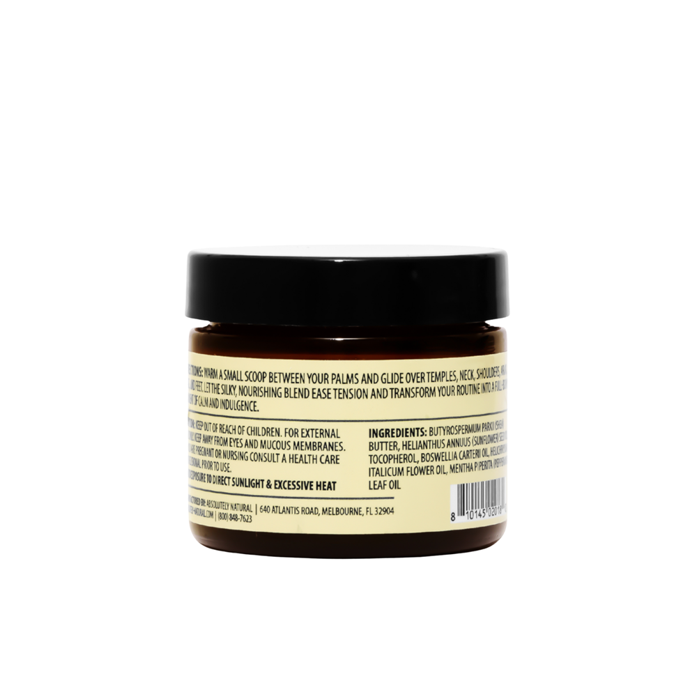 Back view of Kinsley Oils Massage Butter in an amber jar with a black lid, showing the product directions, ingredients, and safety information on a cream-colored label against a white background.
